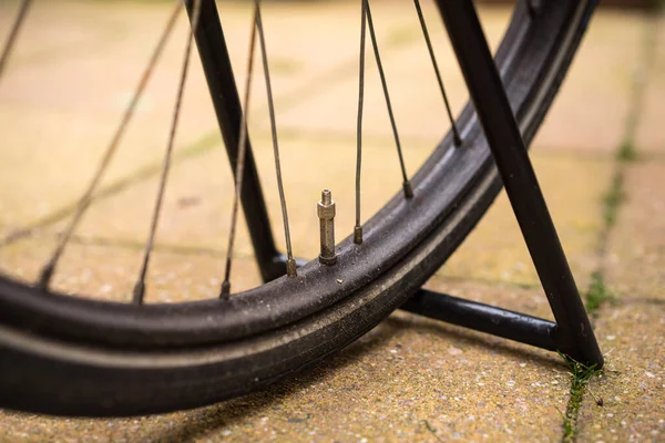 A Parked black bike wheel close up with perspective view