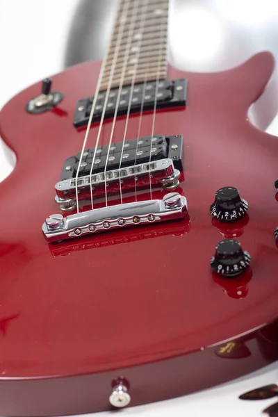 白い背景にボタンと弦の付いた赤いエレキギターのクローズアップ — ストック写真