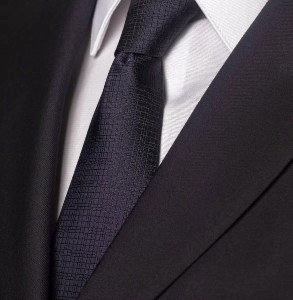 Close up of a black business suit and black tie