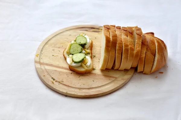 Bir kesme tahtası üzerinde bir salatalık sandviç