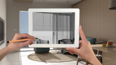 Klasik beyaz ve ahşap oturma odası detaylarını gösteren tablet üzerinde el ele tutuşmalar ve çizimler CAD çizimleri. Arka planda gerçekten bitmiş iç mimari tasarım sunumu
