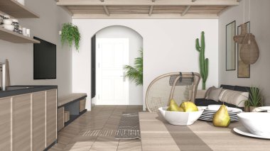 İskandinav etnik oturma ve yemek odası, gri ve ahşap mutfak. Koltuk, sandalyeli yemek masası, halı ve kolye lambaları. Saksı bitkileri. Modern iç tasarım fikri