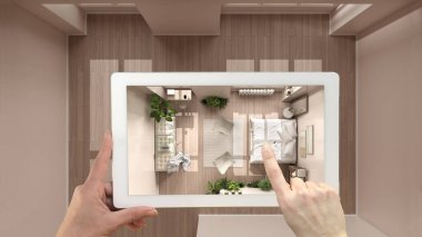 Gelişmiş gerçeklik kavramı. El ele tutuşma tableti ve AR uygulaması parke, eko yatak odası üst görünümü, yukarıda boş iç mekan ve tasarım ürünleri simülasyonu için kullanılır.