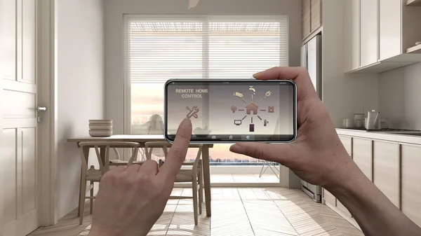 Remote home control system on a digital smart phone tablet. Device with app icons. Interior of scandinavian kitchen with panoramic window in the background, architecture design