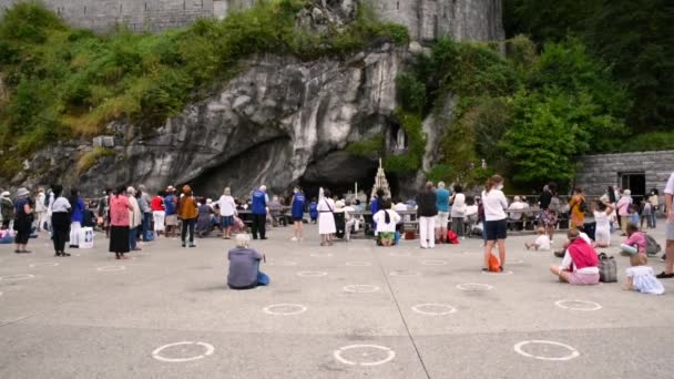 LOURDES, FRANÇA - 16 DE AGOSTO DE 2020: As pessoas rezam na gruta da Basílica de Lady of Lourdes, em Lourdes — Vídeo de Stock