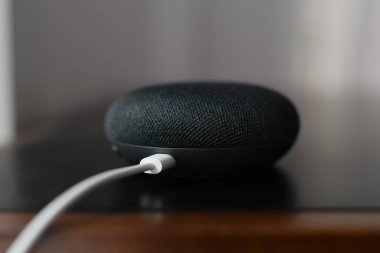 Paris, Fransa - 20 Eylül 2021: Google Home Mini kablolu siyah fiziksel mikrofon düğmesi