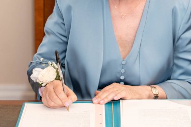 Gelin, evlilik belgelerini imzalar.