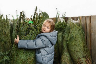 Marketten Noel ağacı alan bir kız..