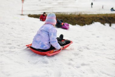 Karda kızakla kayan bir kız