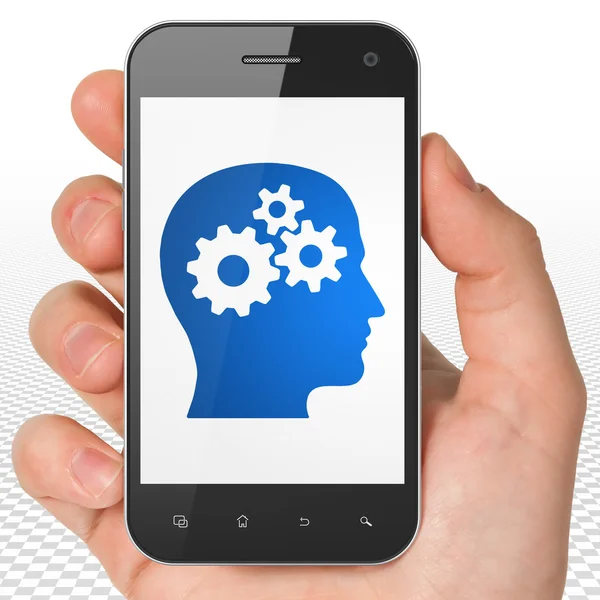 Utbildning koncept: Hand hålla Smartphone med huvud med redskap på displayen — Stockfoto