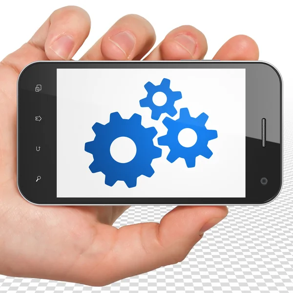 Business koncept: Hånd Holding Smartphone med Gears på displayet - Stock-foto