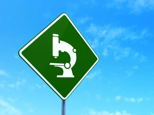 Science concept: Microscope on road sign background — Stock Photo, Image