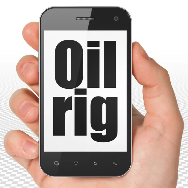 Manufacuring concept: Hand Holding Smartphone with Oil Rig on display — Stok fotoğraf