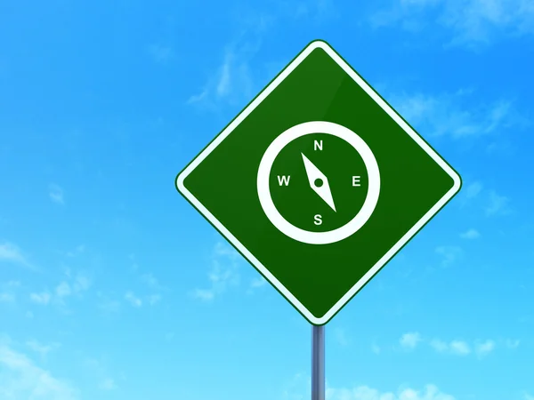 Travel concept: Compass on road sign background — Stok fotoğraf