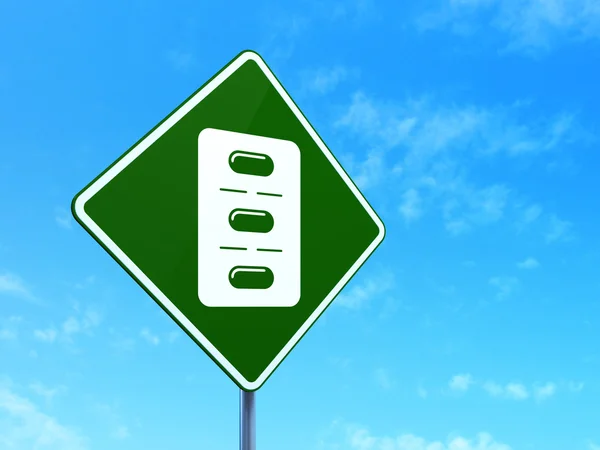 Health concept: Pills Blister on road sign background — Stock Photo, Image