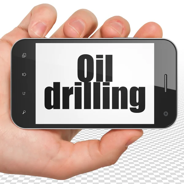 Industry concept: Hand Holding Smartphone with Oil Drilling on display — Stok fotoğraf
