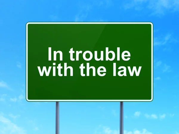 Law concept: In trouble With The law on road sign background — Stock fotografie