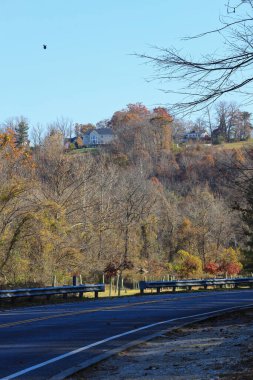 Baltimore, Maryland, ABD 'de tepelerde evleri olan Loch Raven Parkı boş yol.