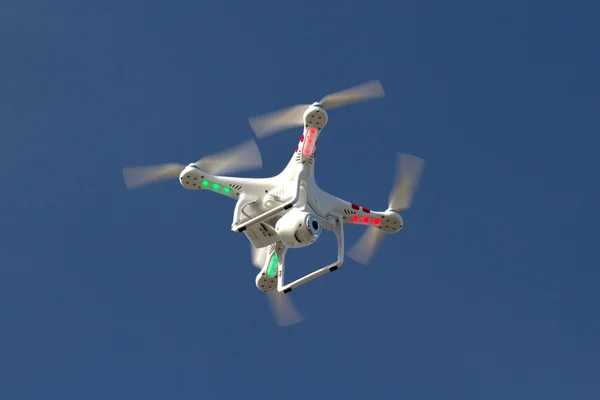Mavi gökyüzünde yüzen bir kamera ile küçük insansız helikopter — Stok fotoğraf