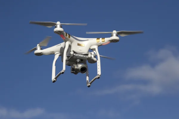 Kleiner unbemannter Hubschrauber mit Kamera am blauen Himmel Stockfoto