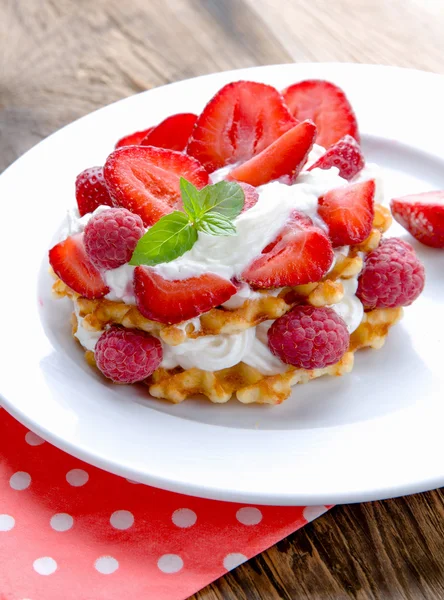 Waffles belgas com morangos, framboesas e creme . — Fotografia de Stock