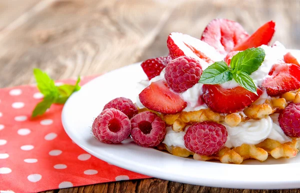 Waffle dengan stroberi dan raspberry dengan latar belakang kayu. Konsep untuk makan sehat . — Stok Foto