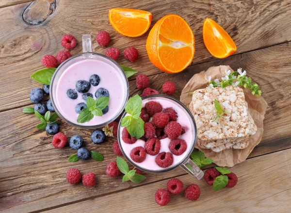 Breakfast. Yogurt with berries blueberries and raspberries, slices and ripe orange.Healthy eating. — Stock Photo, Image