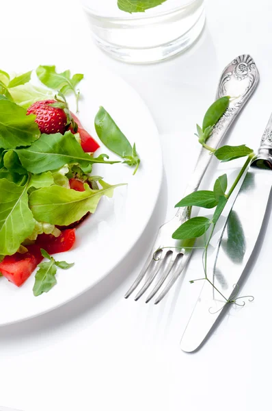 Čerstvý zelený salát s zralá rajčata, lusky zelený hrášek a plátky jahoda. — Stock fotografie