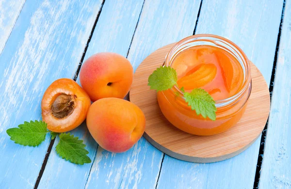 Fresh apricots with jam in glass jar — Stock Photo, Image