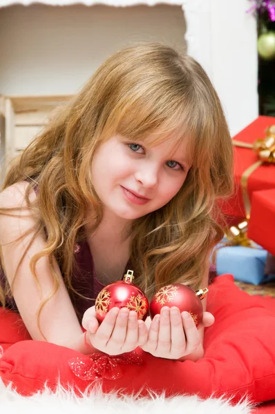 Boldog karácsonyt. Boldog lány az ajándékokat, a kandalló mellett — Stock Fotó