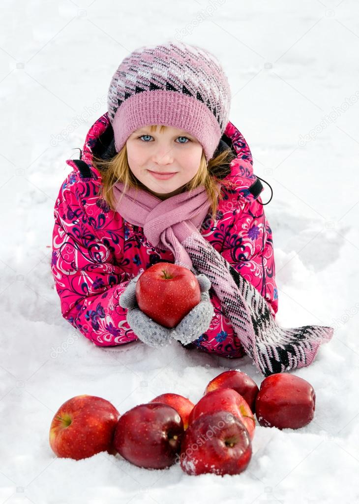 Beautiful girl with red apples on snow