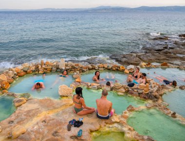 Loutra Edipsou, Evia Adası, Yunanistan. Temmuz 2021: Tatilcilerin panoramik manzarası Yunan spa merkezindeki sıcak su ile kaplıcalarda doğal şifa banyosu yapıyor