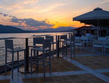 Promenade with taverns and cafes of the spa town of Loutra Edipsou at sunset in the evening on the island of Evia in Greece