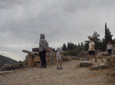 Delphi Greece. May 2021: Tourists wearing masks to protect themselves from the coronavirus walk through the historical complex of Delphi in Greece on a cloudy day