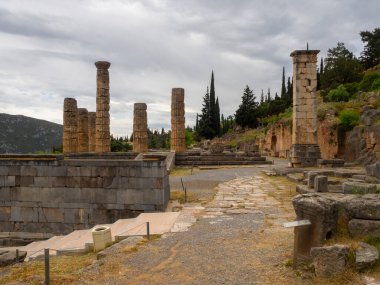 Delphi 'deki Apollo Tapınağı' nın panoramik görüntüsü Yunanistan 'da bulutlu arka plan gökyüzüne karşı