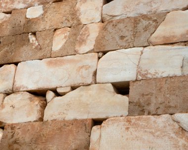 View on an ancient wall with inscriptions and drawings of the Syracuse Treasury Site the with columns in Delphi in Greece