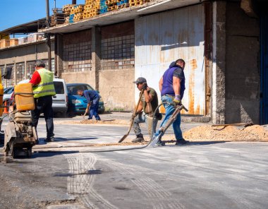 Athens, Greece. July 2021: Workers dig a trench in the asphalt on a road in Athens, Greece