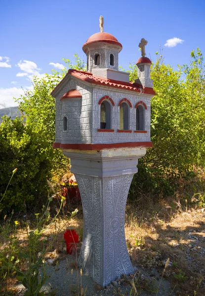 Candelakia - traditional miniature Church by the road with a burning candle and icons inside