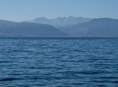 Ufuktaki Parnassus dağları ve Yunanistan 'daki sakin Ege Denizi minimalist bir tarzda