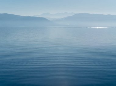 Ufuktaki Parnassus dağları ve Yunanistan 'daki sakin Ege Denizi minimalist bir tarzda