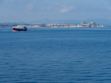 Kerkyra, Korfu, Yunanistan. 30 Ekim 2025: Bir yolcu feribotu Yunanistan 'daki Korfu adasının arka planına doğru yola çıktı