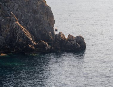 Yunanistan 'ın Korfu kentindeki Paleokastritsa tatil beldesinde panoramik deniz manzarası, balıkçı tekneleri ve turistik tekneler
