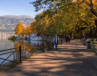 Ioannina, Yunanistan. 1 Kasım 2025: Yunanistan 'ın Epirus dağlarındaki Ioannina' da Pamvotida Gölü kıyısında turistler ve gezi tekneleri