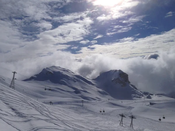 Una escena de esquí de montaña bajo un cielo azul brillante con nubes — Foto de Stock