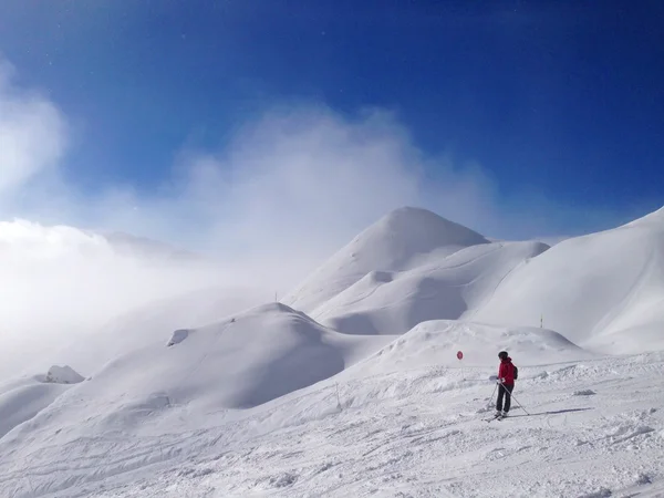 Een skiër op de piste voor prachtige bergen — Stockfoto