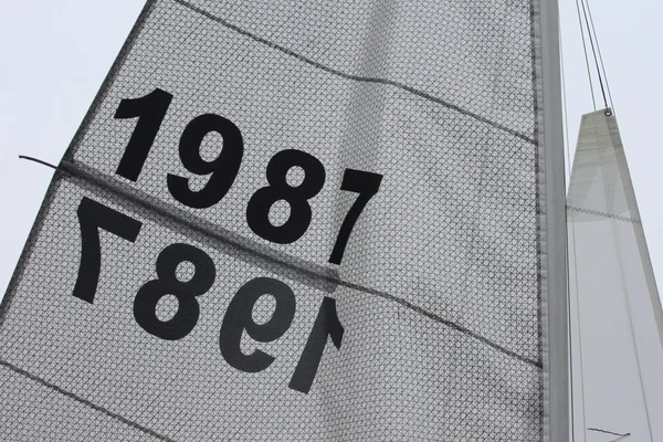 Sails flapping in the breeze with number 1987 — Stock Photo, Image