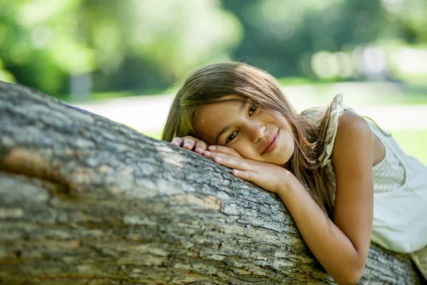 Meisje liggend op een boom — Stockfoto