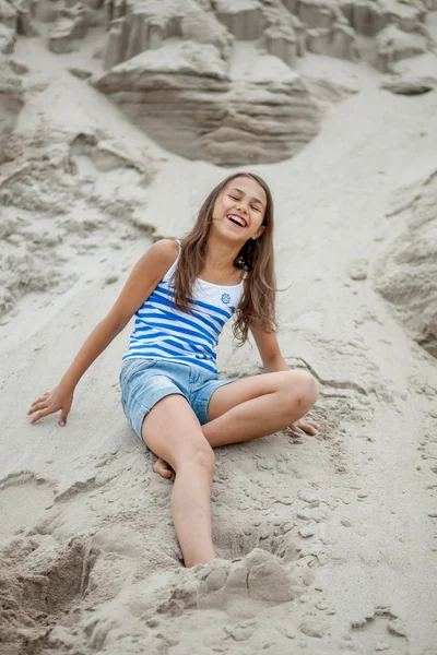 Menina em um colete listrado na areia — Fotografia de Stock