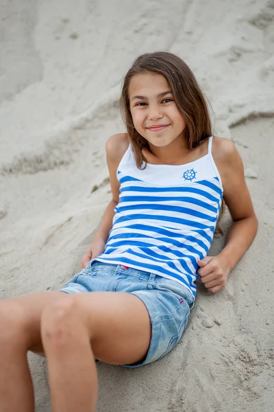 Mädchen in gestreifter Weste im Sand — Stockfoto