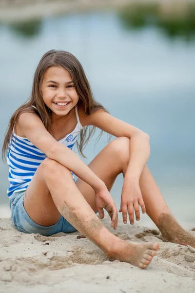 Menina em um colete listrado na areia — Fotografia de Stock